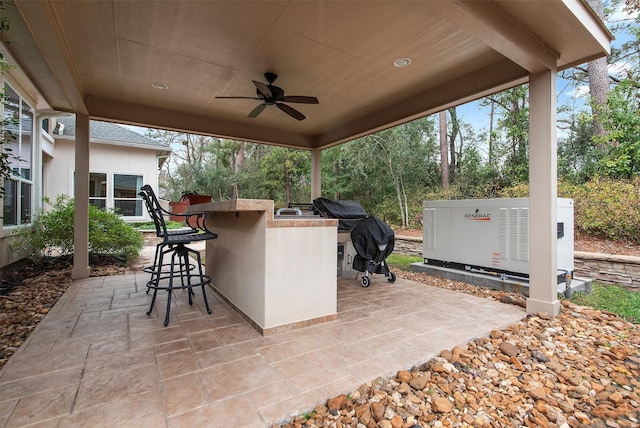 view of patio / terrace with a grill, exterior kitchen, ceiling fan, and exterior bar