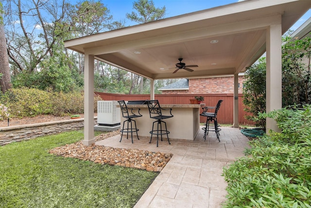 view of patio featuring exterior bar and ceiling fan