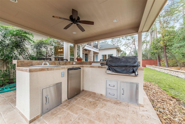 view of patio / terrace featuring grilling area, ceiling fan, and exterior kitchen