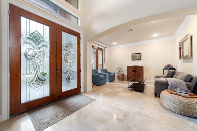 entryway featuring ornamental molding, a wealth of natural light, and french doors