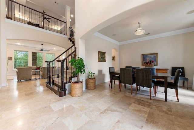 dining space with crown molding and a high ceiling