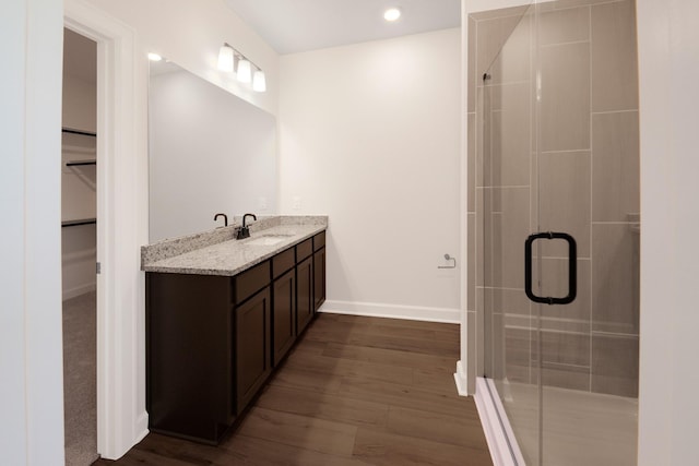 bathroom featuring vanity, an enclosed shower, and wood-type flooring