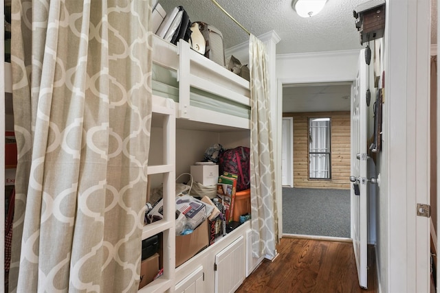 bedroom with crown molding, dark hardwood / wood-style floors, and a textured ceiling