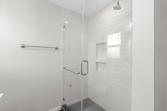 bathroom featuring a shower with shower door