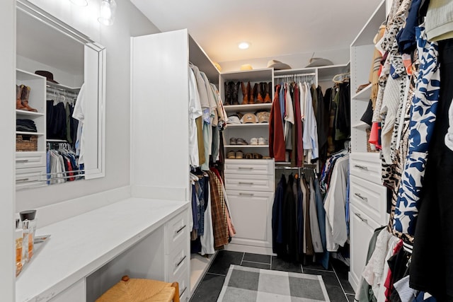 spacious closet with dark tile patterned floors