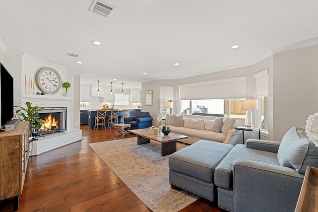 living room with dark hardwood / wood-style floors, a fireplace, and crown molding