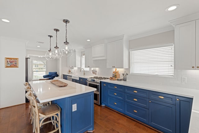 kitchen featuring a kitchen island, appliances with stainless steel finishes, pendant lighting, white cabinets, and blue cabinetry