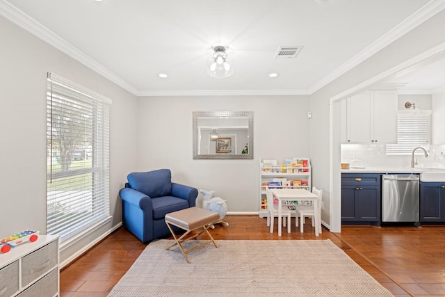 sitting room with dark wood-type flooring, ornamental molding, a healthy amount of sunlight, and sink