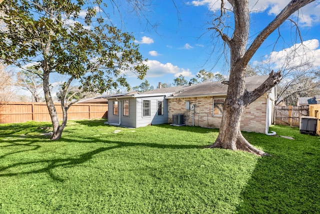 rear view of property featuring cooling unit and a lawn