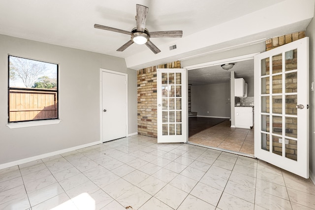 spare room featuring ceiling fan and french doors