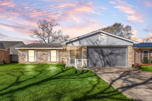 ranch-style house featuring a garage and a lawn