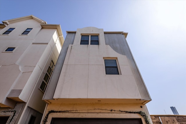 view of side of property with an attached garage and stucco siding