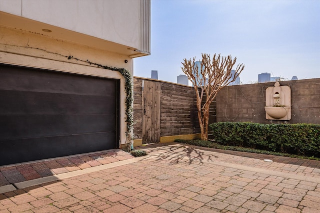 garage featuring driveway and fence