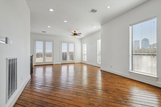 unfurnished living room with hardwood / wood-style flooring, baseboards, visible vents, and recessed lighting