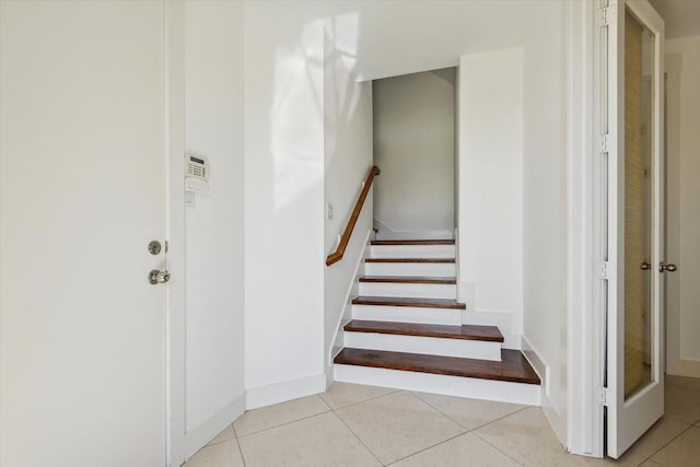 staircase with tile patterned flooring and baseboards