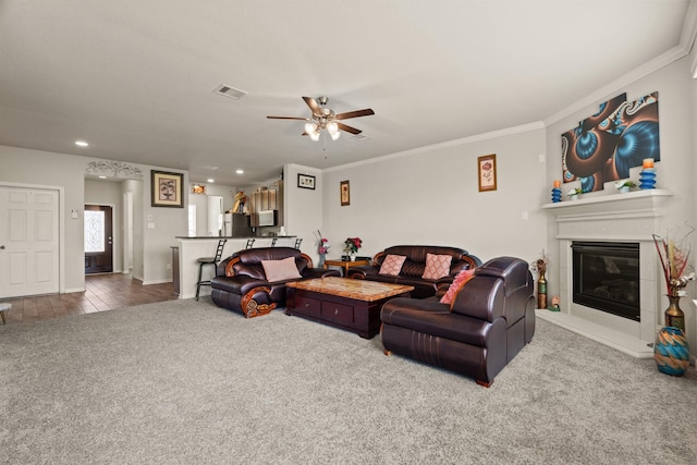 living room featuring crown molding, carpet flooring, and ceiling fan