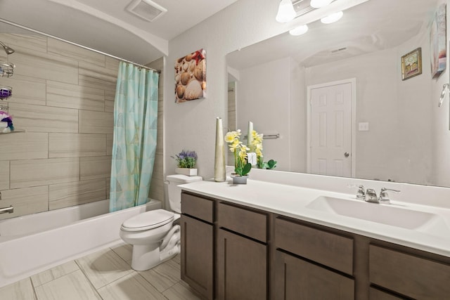 full bathroom with shower / tub combo with curtain, vanity, and toilet