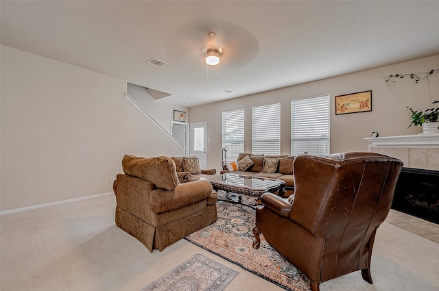 carpeted living room featuring ceiling fan and a fireplace