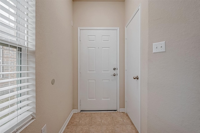 doorway to outside with light tile patterned flooring