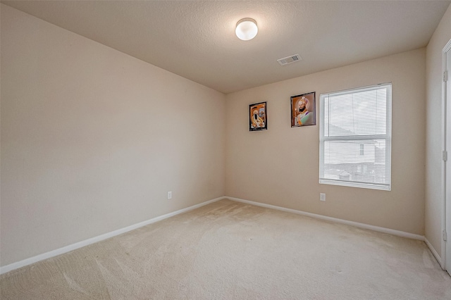 carpeted empty room featuring a textured ceiling