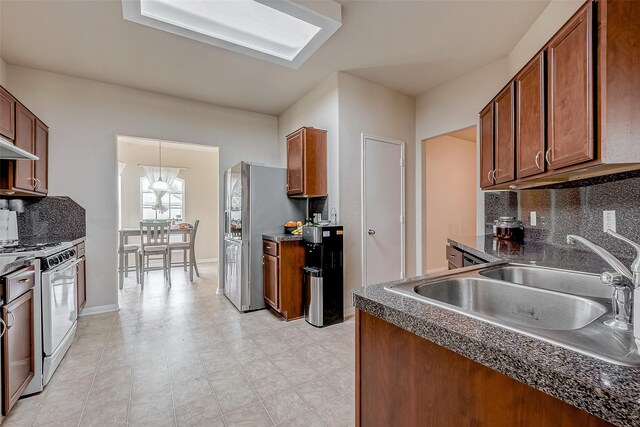 kitchen featuring sink, decorative backsplash, range hood, and white gas range oven