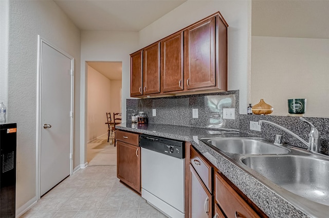 kitchen featuring stainless steel dishwasher, sink, decorative backsplash, and light tile patterned floors