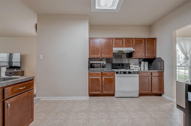 kitchen featuring tasteful backsplash, sink, and white gas range oven