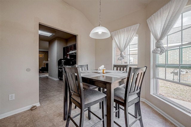 tiled dining space with lofted ceiling