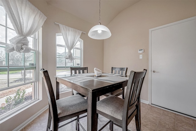 dining space featuring vaulted ceiling and light tile patterned floors