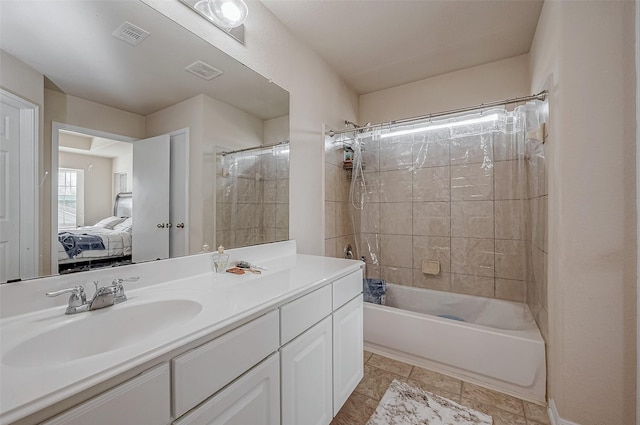 bathroom with tiled shower / bath and vanity