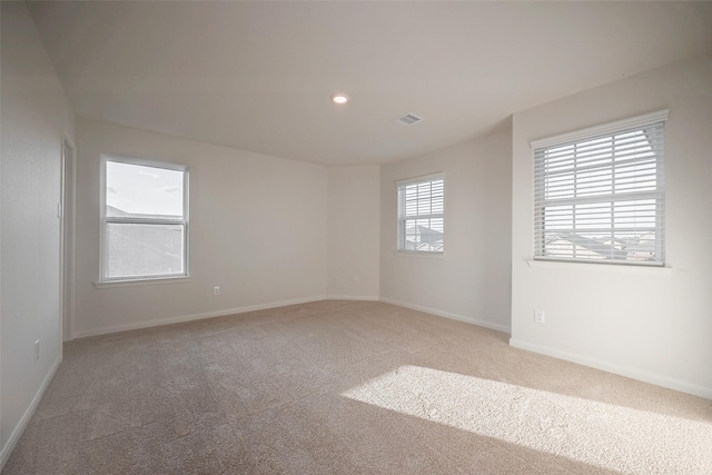 carpeted spare room featuring a wealth of natural light