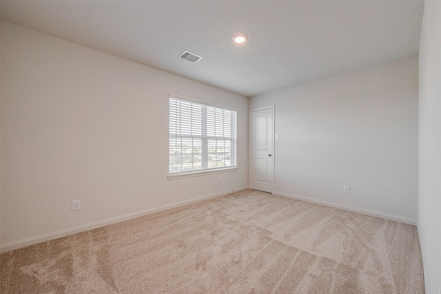 unfurnished room featuring light carpet