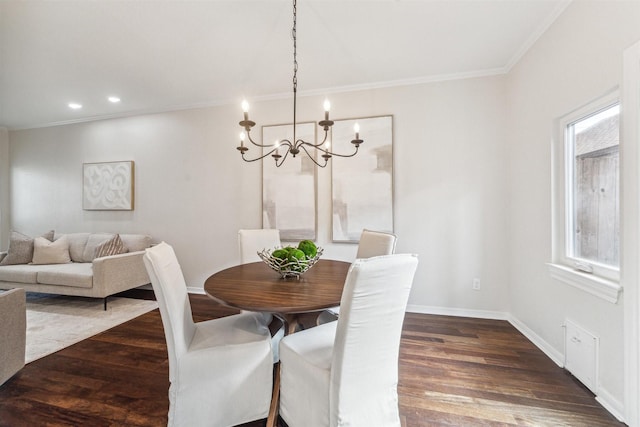 dining room featuring dark wood-type flooring, ornamental molding, and a chandelier