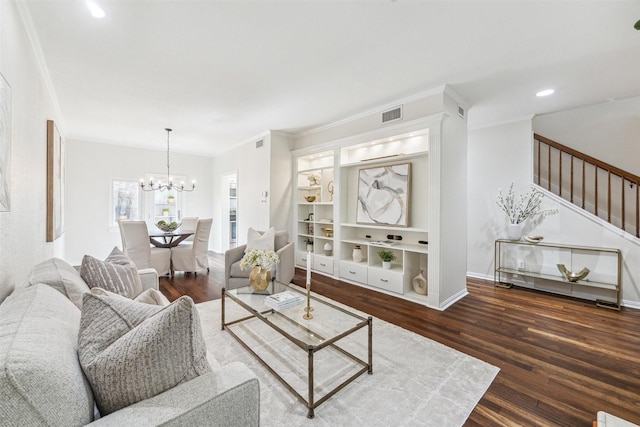 living room with built in shelves, ornamental molding, dark hardwood / wood-style floors, and a chandelier