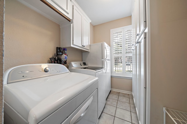 laundry room with cabinets, light tile patterned flooring, and separate washer and dryer