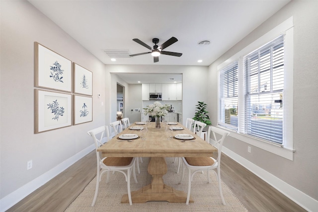 dining space with ceiling fan and light hardwood / wood-style floors