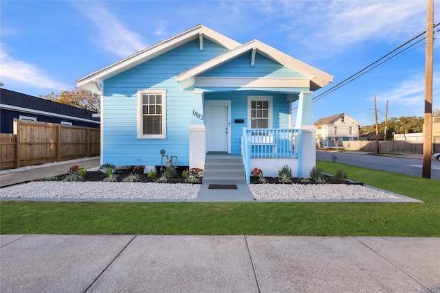 bungalow featuring a front lawn and a porch