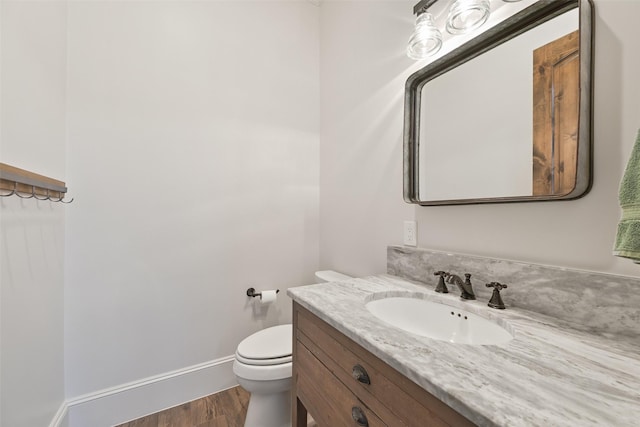 bathroom featuring vanity, toilet, and hardwood / wood-style floors