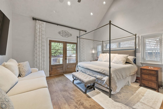 bedroom featuring high vaulted ceiling, access to exterior, light wood-type flooring, and french doors