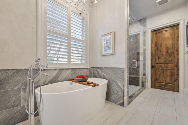 bathroom with tile walls, tile patterned floors, and independent shower and bath