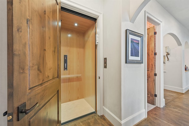 hallway featuring elevator and wood-type flooring