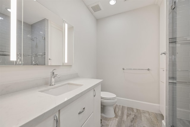 bathroom featuring vanity, wood-type flooring, a shower, and toilet