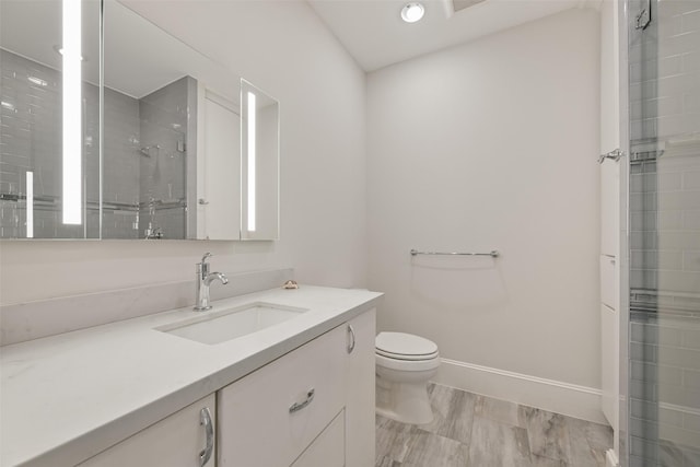 bathroom featuring vanity, toilet, and a shower