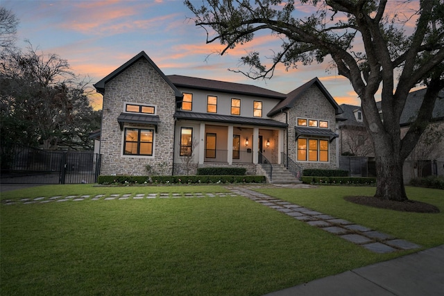 view of front facade featuring covered porch and a lawn