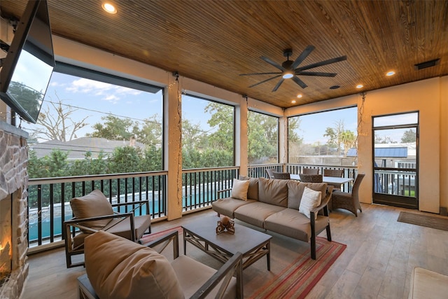 sunroom / solarium with wood ceiling and ceiling fan