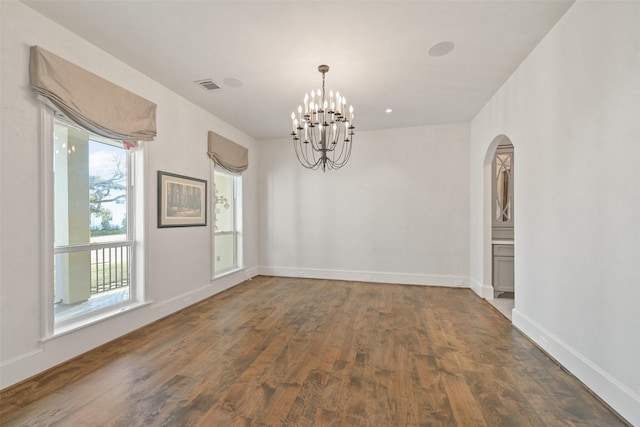 unfurnished dining area featuring a notable chandelier and dark wood-type flooring