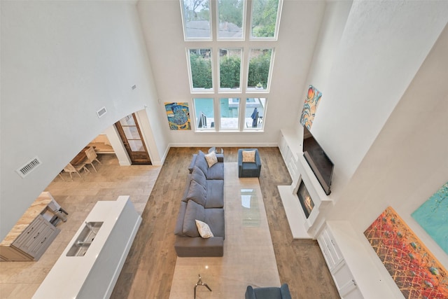 living room with hardwood / wood-style floors, sink, and a high ceiling