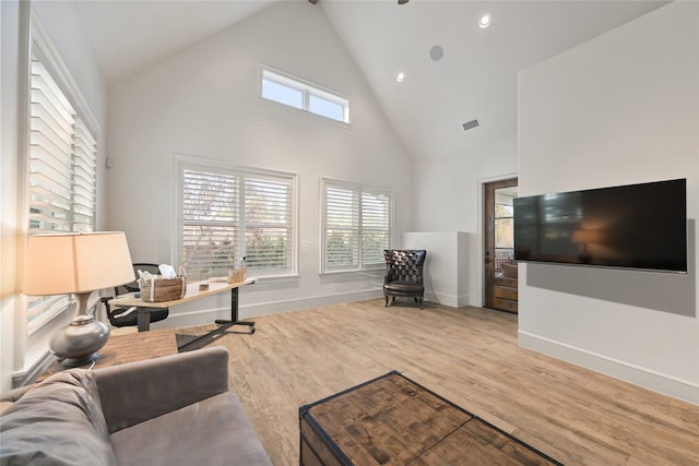 living room with high vaulted ceiling and light wood-type flooring