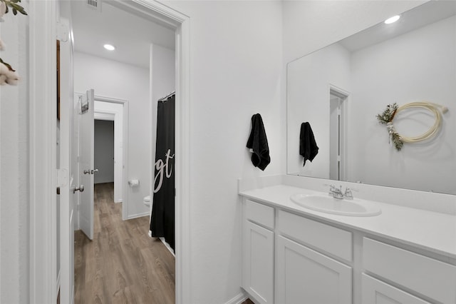 bathroom featuring vanity, toilet, and wood-type flooring