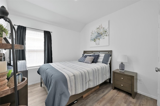 bedroom featuring hardwood / wood-style floors and vaulted ceiling